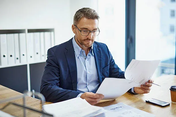 A professional reviewing a set of printed documents