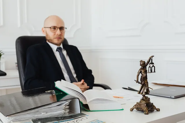 A legal professional reviewing documents at his desk