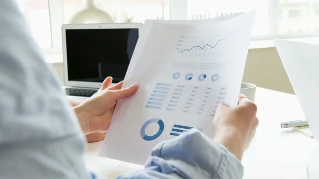 Printed reports and charts being reviewed at a desk