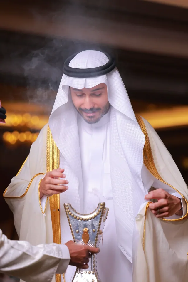 A man holding a traditional coffee pot