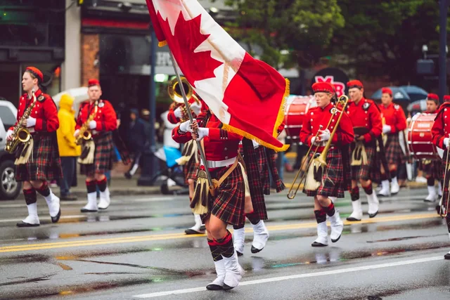 Parade participants carrying a Canadian flag