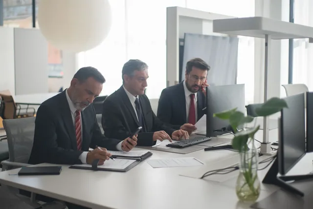 Professionals reviewing documents around a meeting table