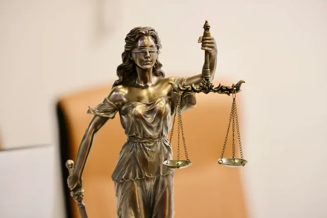 Crest translation services: a Lady Justice statue with scales in a legal setting