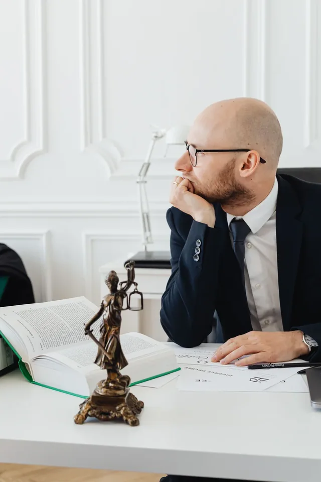 Translation services Crest translation services: a legal professional sitting beside reference books and a justice statue