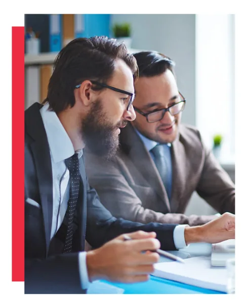 Crest translation services: two professionals working together and reviewing information at a desk