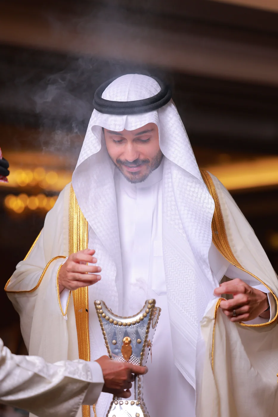 A man holding a traditional coffee pot