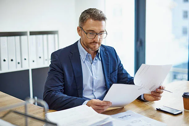 A professional reviewing a set of printed documents