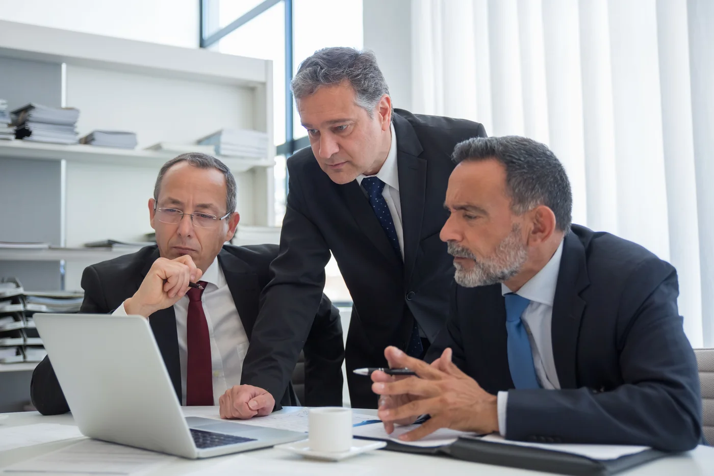 Professionals reviewing material together at a laptop